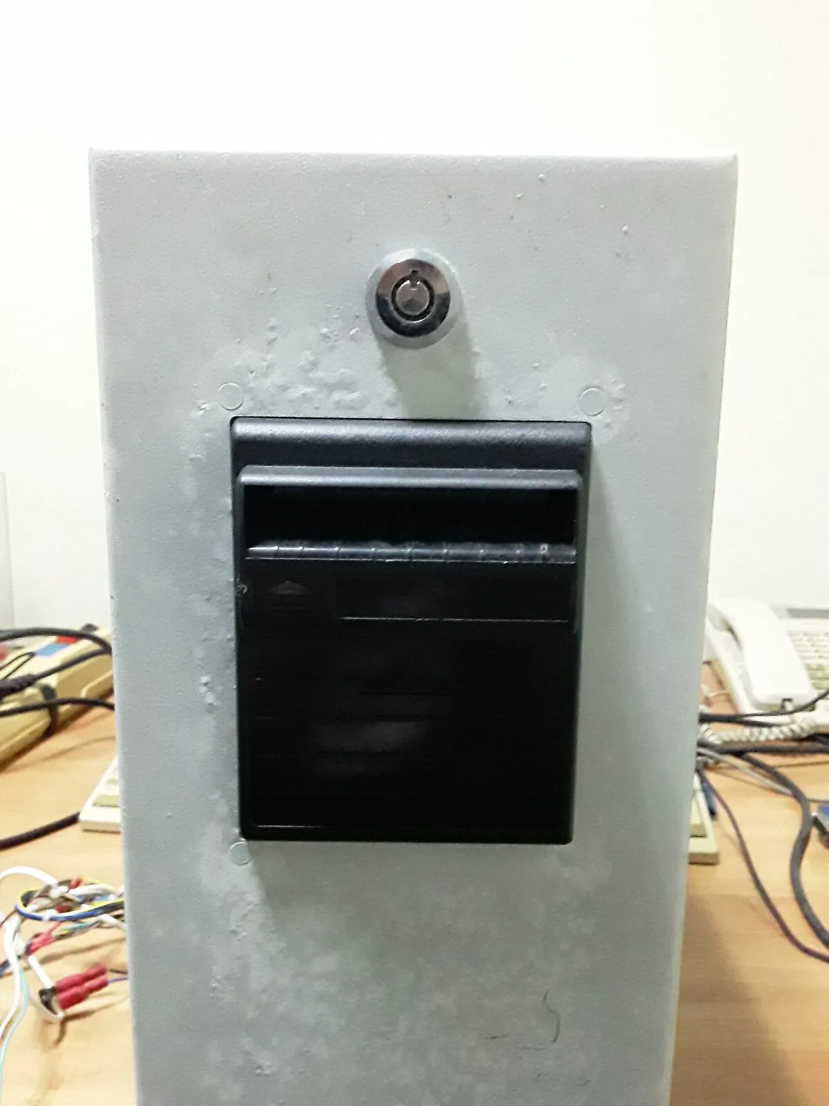A black note validator slot mounted in a pale panel